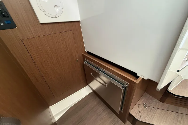 Slide: The Image of 2026 Beneteau Antares 11 Fly interior with wood paneling and built-in storage. - 18