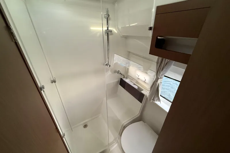 Slide: The Image of 2026 Beneteau Antares 11 Fly bathroom with shower, toilet, and window. - 25
