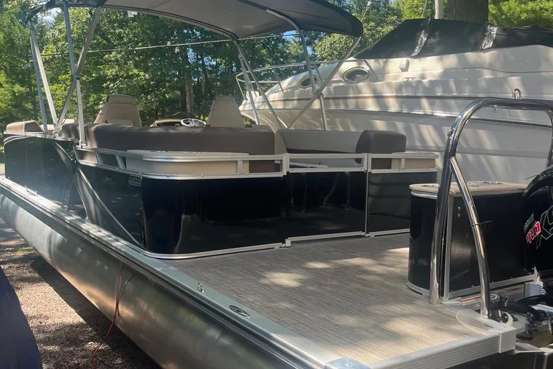 Slide: The Image of 2026 Avalon 25 LSZ Quad Lounger pontoon boat with canopy, docked outdoors. - 8