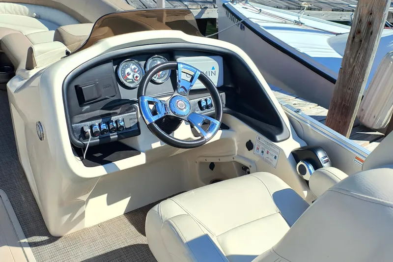 Slide: The Image of 2022 Avalon Catalina Quad Lounge 25 boat interior with steering wheel and control panel. - 13