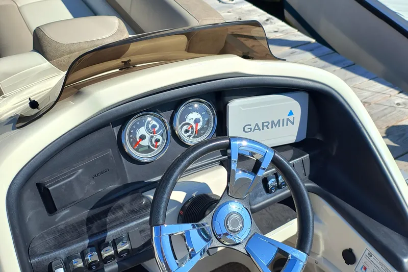 Slide: The Image of 2022 Avalon Catalina Quad Lounge 25 dashboard with Garmin navigation and chrome steering wheel. - 14