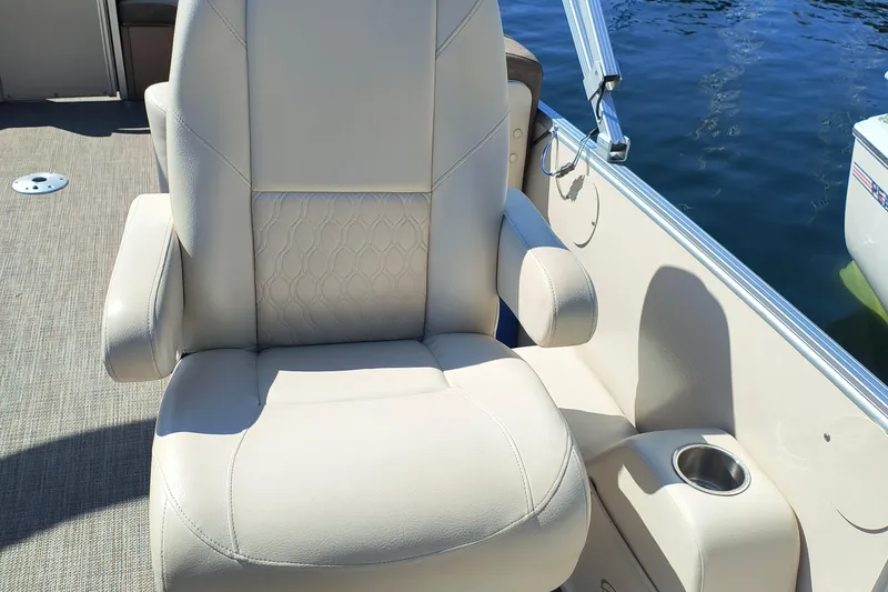 Slide: The Image of Luxurious seating on 2022 Avalon Catalina Quad Lounge 25 boat, featuring beige upholstery and armrests. - 16