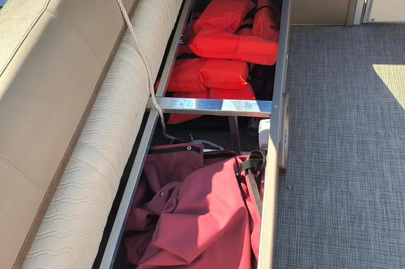 Slide: The Image of Storage compartment with life jackets on a 2022 Avalon Catalina Quad Lounge 25 boat. - 18