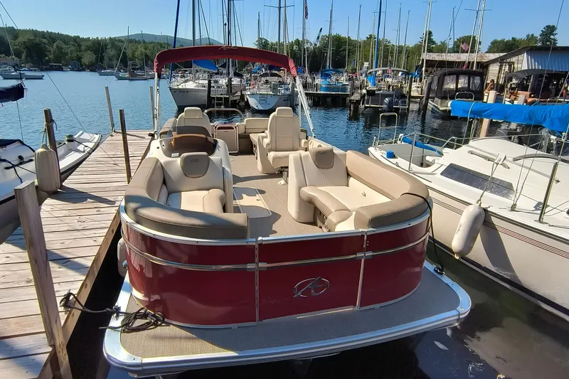 Slide: The Image of 2022 Avalon Catalina Quad Lounge 25 pontoon boat docked at a marina. - 2