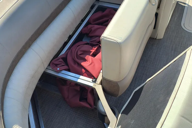 Slide: The Image of 2022 Avalon Catalina Quad Lounge 25 interior storage with red fabric under seat. - 5