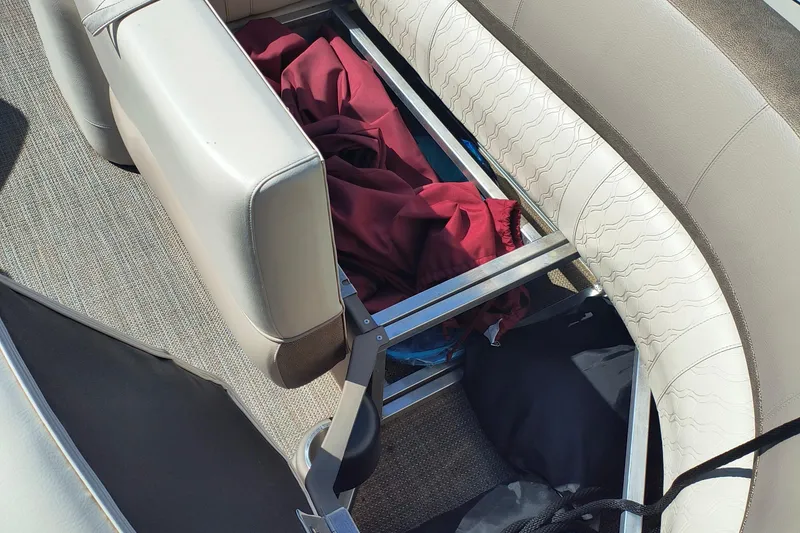 Slide: The Image of 2022 Avalon Catalina Quad Lounge 25 interior storage with red fabric and bags. - 7