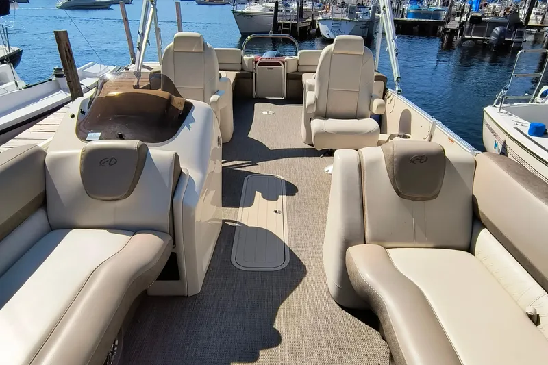 Slide: The Image of 2022 Avalon Catalina Quad Lounge 25 interior with luxurious seating at a marina. - 8
