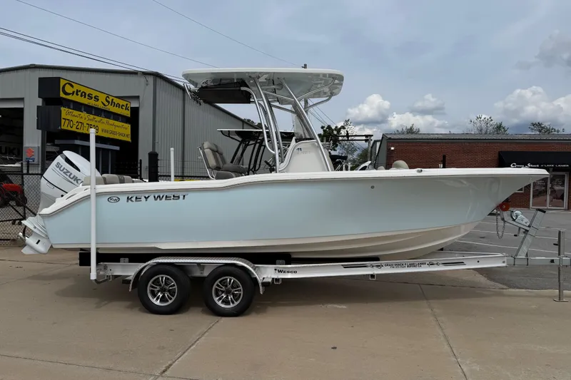 Slide: The Image of 2026 Key West 239 FS boat on trailer, parked outside dealership. - 1