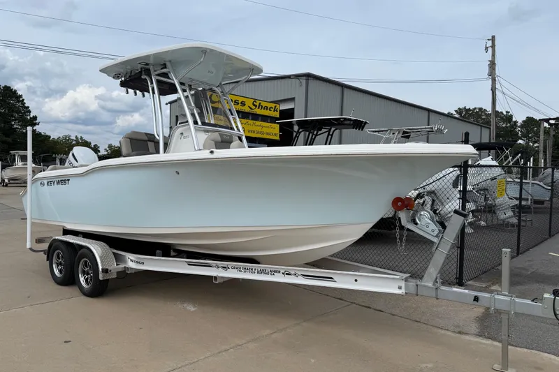 Slide: The Image of 2026 Key West 239 FS boat on trailer, parked outside dealership. - 2