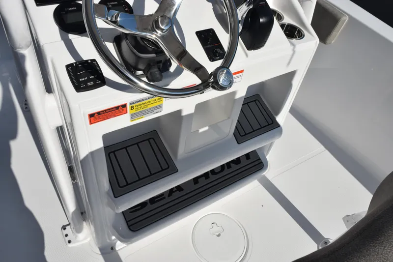 Slide: The Image of 2026 Sea Hunt Ultra 229 boat console with steering wheel and controls. - 16