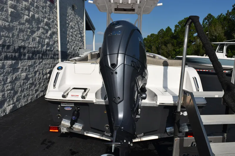 Slide: The Image of 2026 Sea Hunt Ultra 229 boat with powerful outboard motor, parked outdoors. - 5