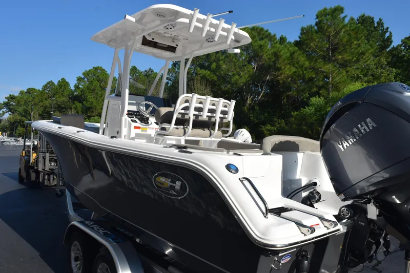 Slide: The Image of 2026 Sea Hunt Ultra 229 boat with Yamaha engine, parked outdoors, surrounded by trees. - 6