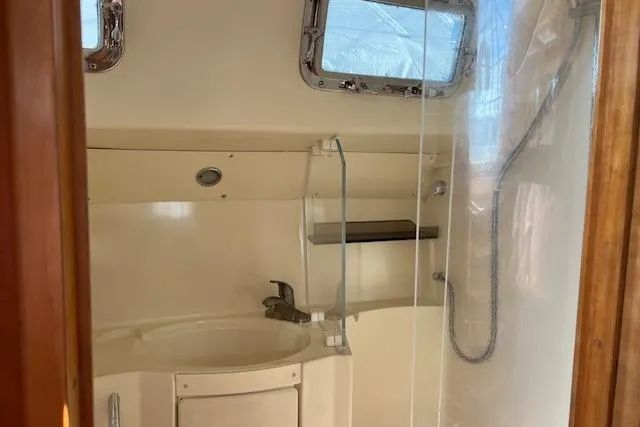 Slide: The Image of 2004 Saga 43CLS yacht bathroom with sink, shower, and porthole window. - 10