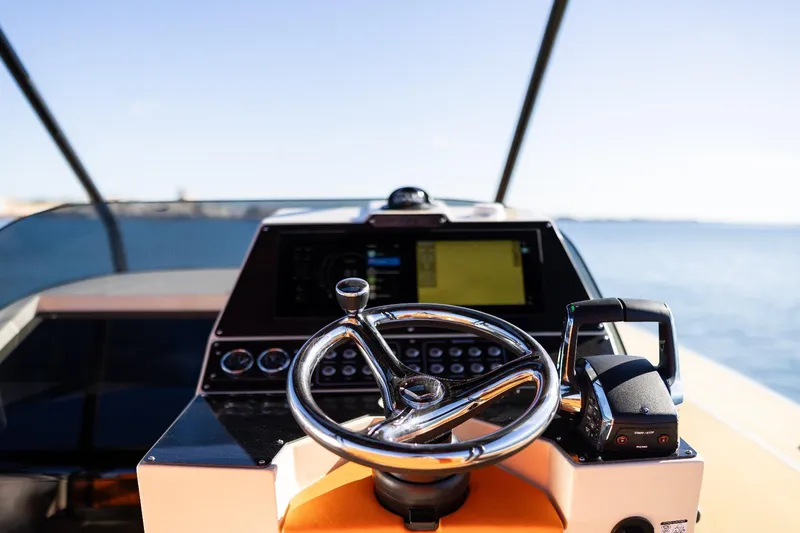 Slide: The Image of 2025 AlCustom LIPARI 31 boat helm with steering wheel and navigation controls. - 13