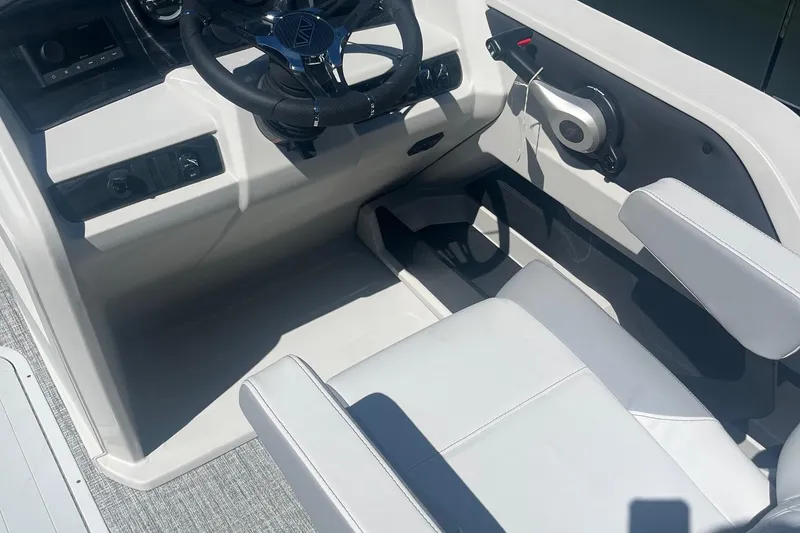 Slide: The Image of Interior of 2026 Avalon 23 Quad Lounger boat, featuring steering wheel and seating. - 5
