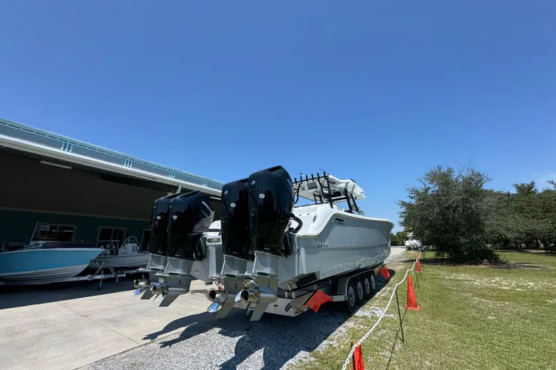 Slide: The Image of 2026 Invincible 46 Catamaran with powerful engines, parked outdoors under clear blue sky. - 10