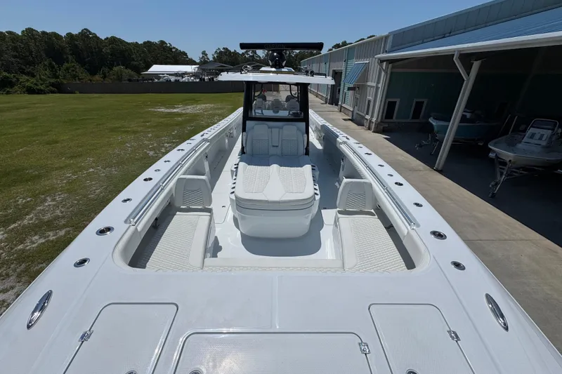 Slide: The Image of 2026 Invincible 46 Catamaran with spacious deck and modern design, docked near a building. - 17