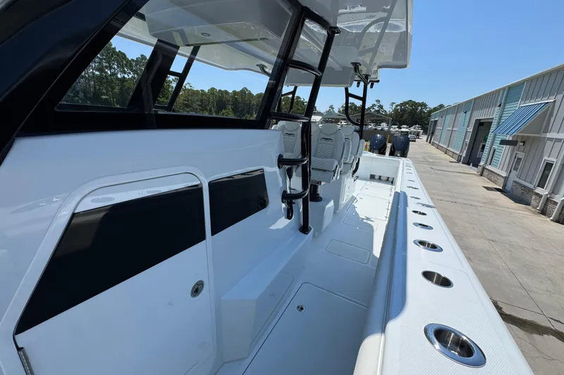 Slide: The Image of 2026 Invincible 46 Catamaran interior with seating and rod holders, docked at marina. - 24