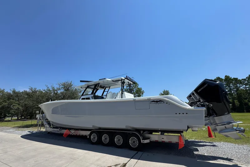 Slide: The Image of 2026 Invincible 46 Catamaran on trailer under clear blue sky. - 3