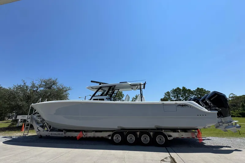 Slide: The Image of 2026 Invincible 46 Catamaran on trailer under clear blue sky. - 4
