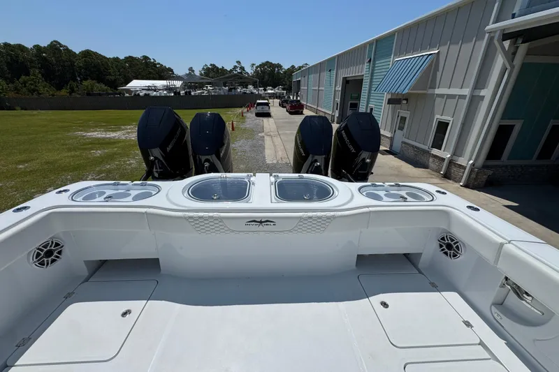 Slide: The Image of 2026 Invincible 46 Catamaran with powerful outboard engines at a marina. - 44