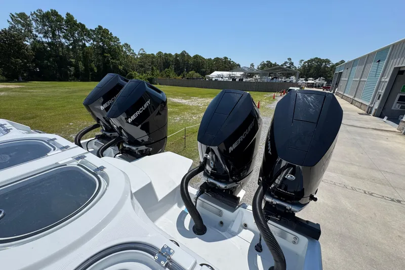 Slide: The Image of 2026 Invincible 46 Catamaran with four Mercury outboard engines, docked outdoors. - 48