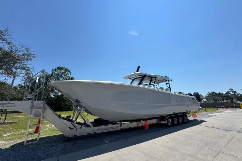 Slide: The Image of 2026 Invincible 46 Catamaran on trailer under clear blue sky. - 5