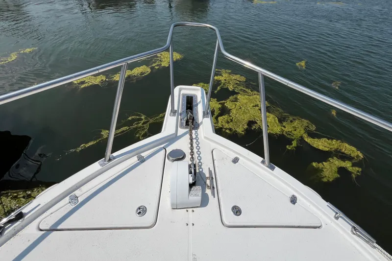 Slide: The Image of Bow view of 2001 Rampage Express 30 Open boat on water with algae. - 10
