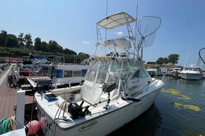 Slide: The Image of 2001 Rampage Express 30 Open boat docked at marina, featuring fishing equipment. - 2