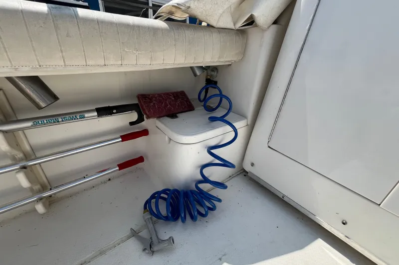 Slide: The Image of 2001 Rampage Express 30 Open boat interior with cleaning tools and coiled hose. - 22