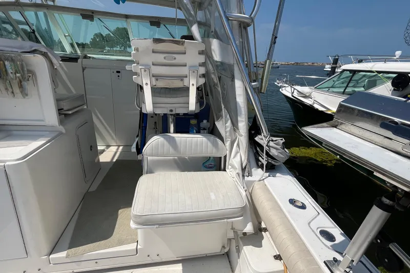 Slide: The Image of 2001 Rampage Express 30 Open boat interior with seating and helm, docked by the water. - 26