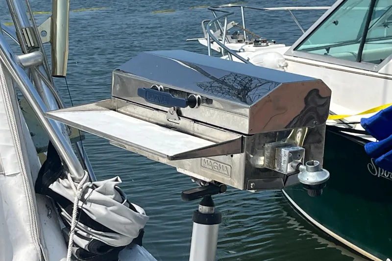 Slide: The Image of Stainless steel grill mounted on a 2001 Rampage Express 30 Open boat by the water. - 27