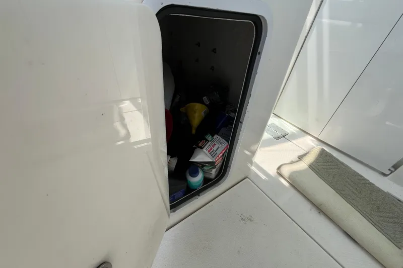 Slide: The Image of Storage compartment on 2001 Rampage Express 30 Open boat, containing various items. - 34