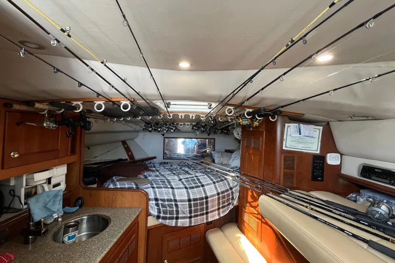 Slide: The Image of Interior of 2001 Rampage Express 30 Open boat with fishing rods and cozy cabin. - 38