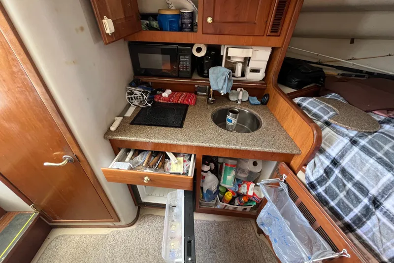 Slide: The Image of 2001 Rampage Express 30 Open boat interior with kitchenette and storage. - 42