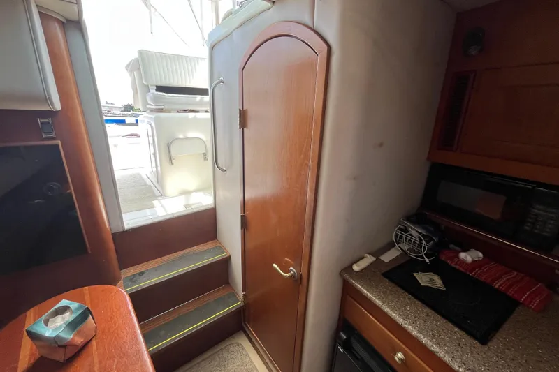 Slide: The Image of Interior of 2001 Rampage Express 30 Open boat, featuring stairs and kitchenette area. - 48