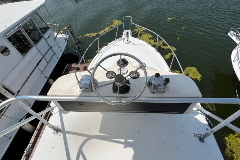 Slide: The Image of 2001 Rampage Express 30 Open boat helm with steering wheel and controls, docked on water. - 5