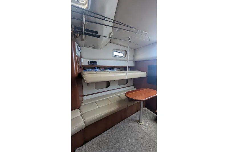 Slide: The Image of 2001 Rampage Express 30 Open cabin interior with seating, table, and fishing rods. - 57