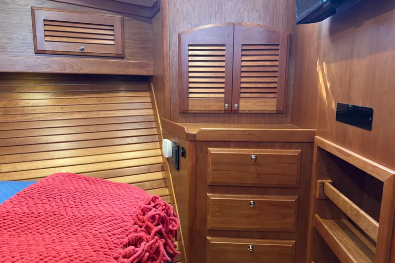Slide: The Image of 2016 Sabre Craft Salon Express interior with wooden cabinetry and red blanket. - 15
