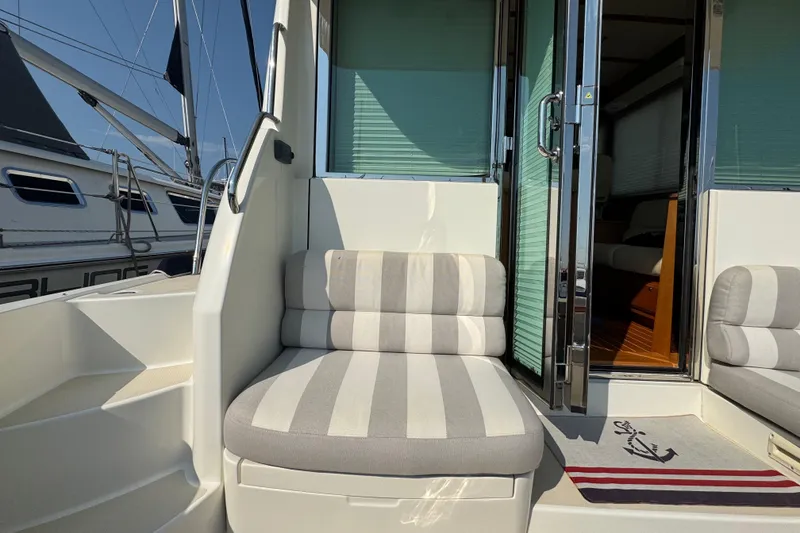 Slide: The Image of 2016 Sabre Craft Salon Express yacht interior with striped seating and open glass door. - 22