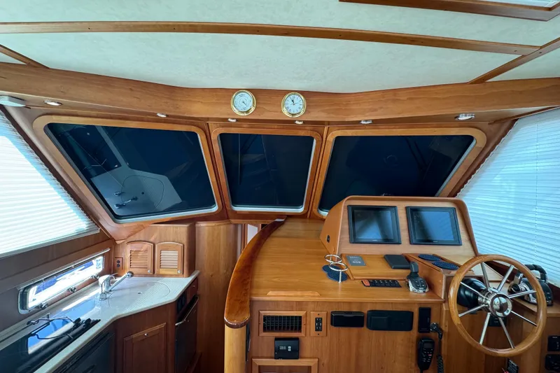Slide: The Image of 2016 Sabre Craft Salon Express helm with wooden interior and modern navigation equipment. - 4