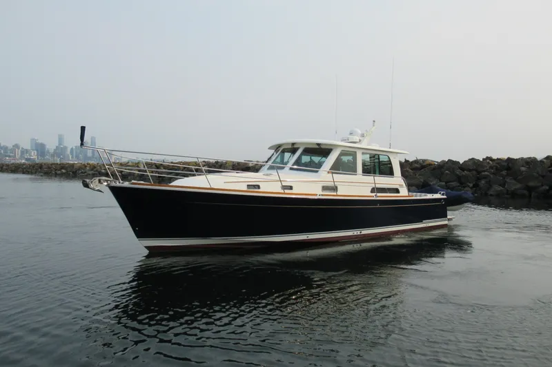 The Image of 2016 Sabre Salon Express yacht on calm water near rocky shoreline. - 0