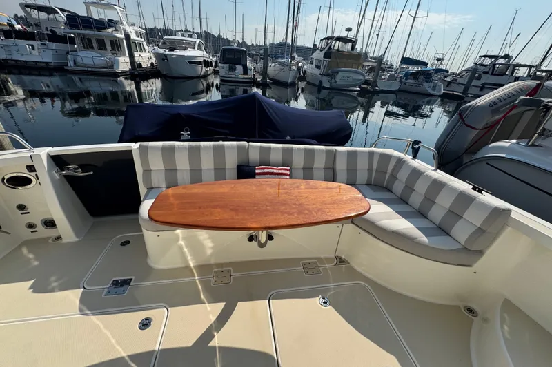 Slide: The Image of 2016 Sabre Craft Salon Express yacht with striped seating and wooden table in marina. - 21