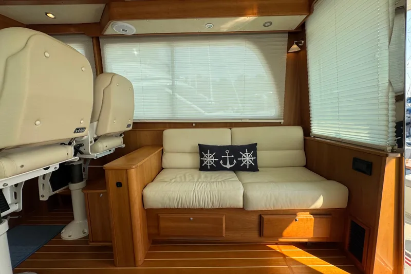 Slide: The Image of 2016 Sabre Craft Salon Express interior with beige seating, nautical-themed pillow, and wooden accents. - 8