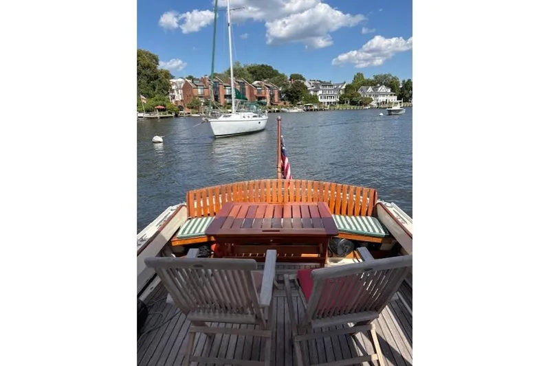 Slide: The Image of 1960 Dyer Hard Top boat with deck chairs, table, and scenic waterfront view. - 10