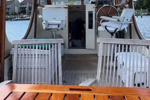 Slide: The Image of 1960 Dyer Hard Top boat interior with wooden deck and seating, docked by the water. - 11