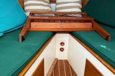 Slide: The Image of 1960 Dyer Hard Top boat interior with green cushions and wooden table. - 13