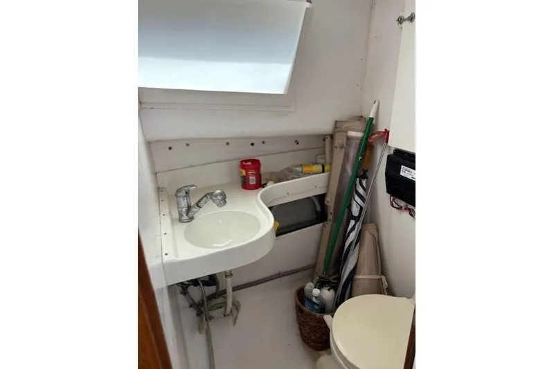 Slide: The Image of Small bathroom on a 1960 Dyer Hard Top boat, featuring a sink and storage items. - 14