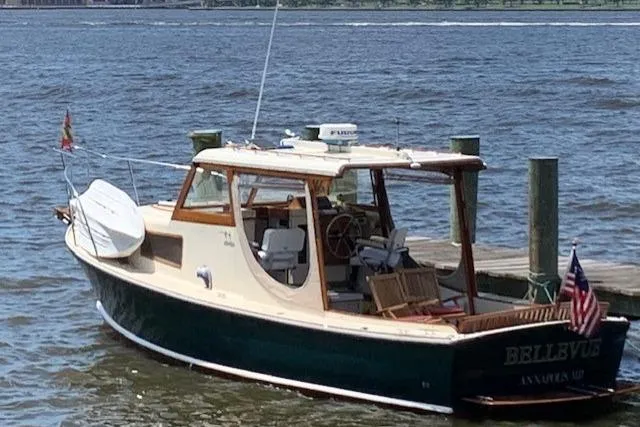 Slide: The Image of 1960 Dyer Hard Top boat with flush deck docked on a sunny day. - 2