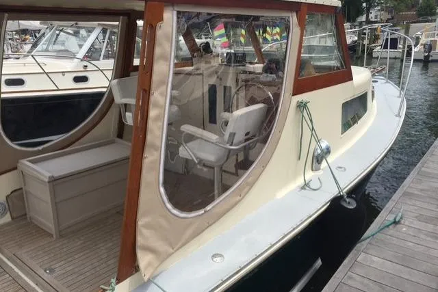 Slide: The Image of 1960 Dyer Hard Top boat with flush deck, docked, featuring wooden trim and enclosed seating area. - 3